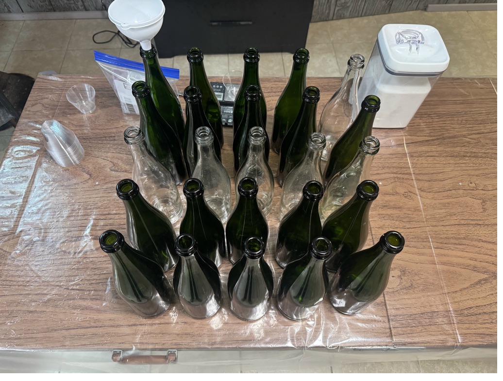 Rows of bottles lined up on a table before bottling