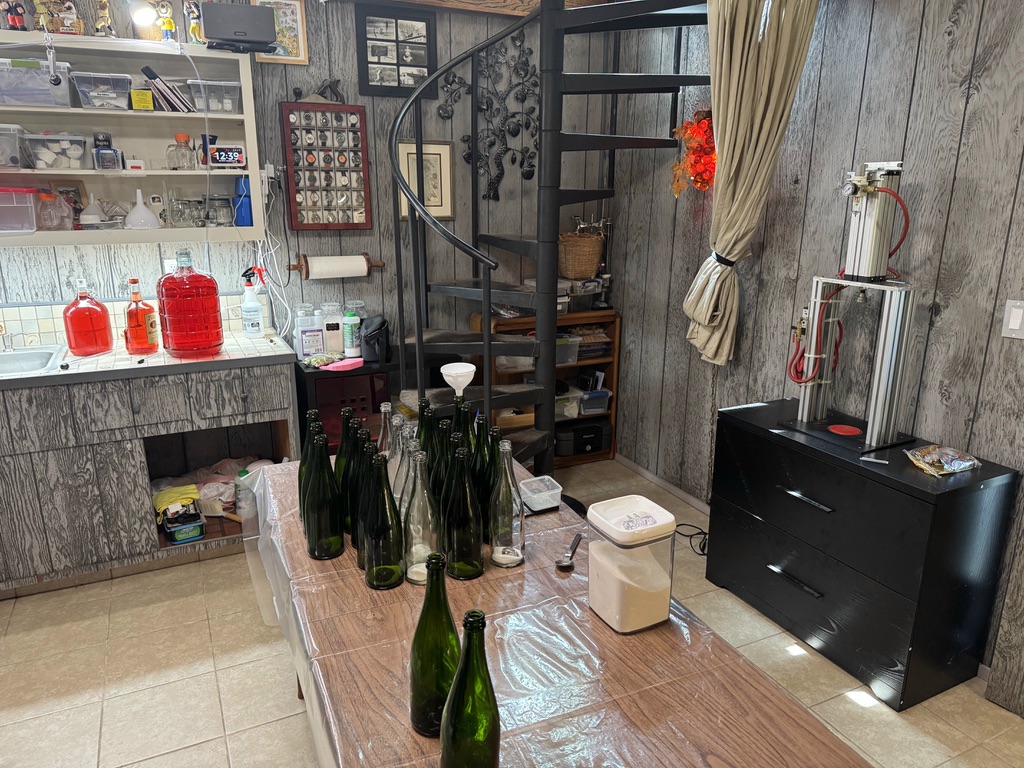The winemaking room with spiral staircase and bottles on table